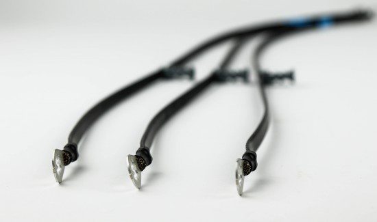F2A0455-550x325 a white background with a group of five black wires or cords laid out on it